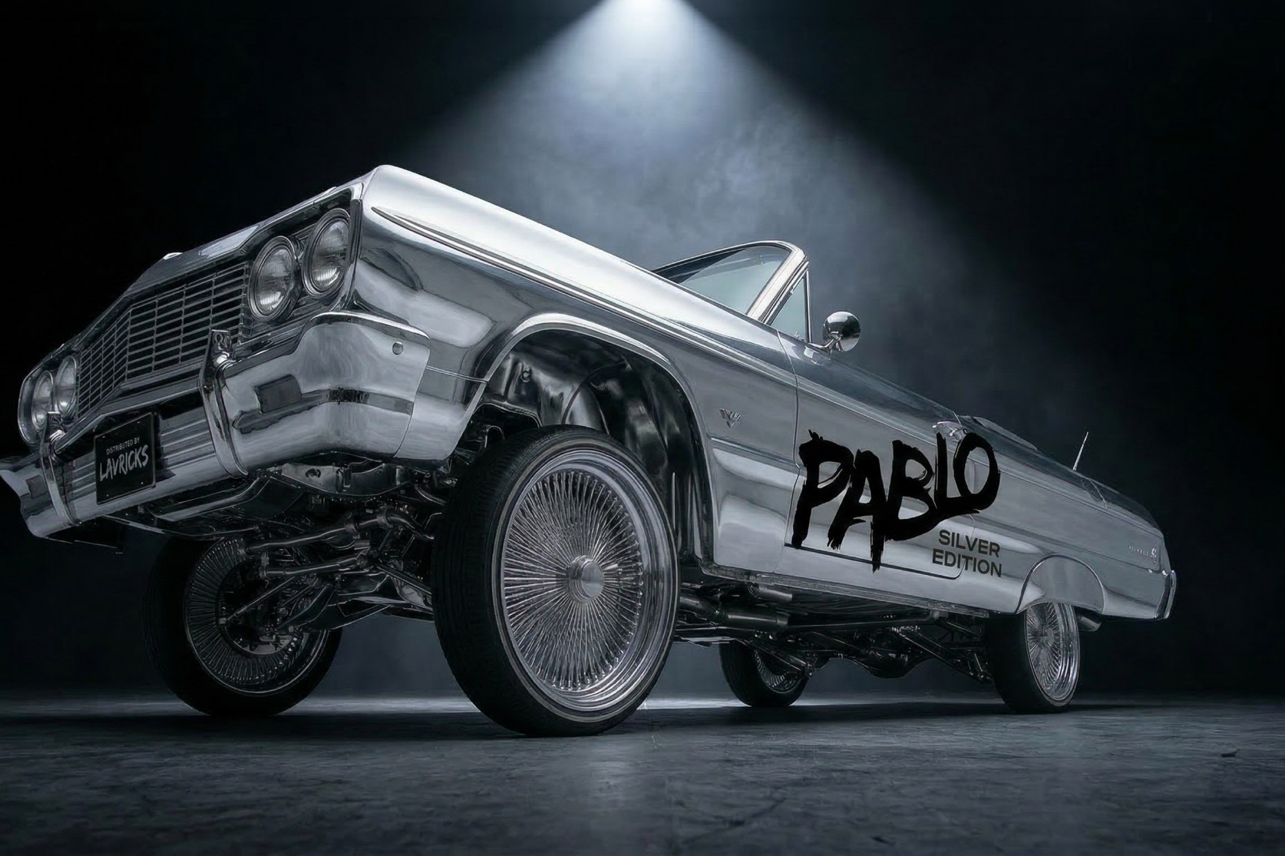 A lowrider on hydraulics under a single hard studio light.